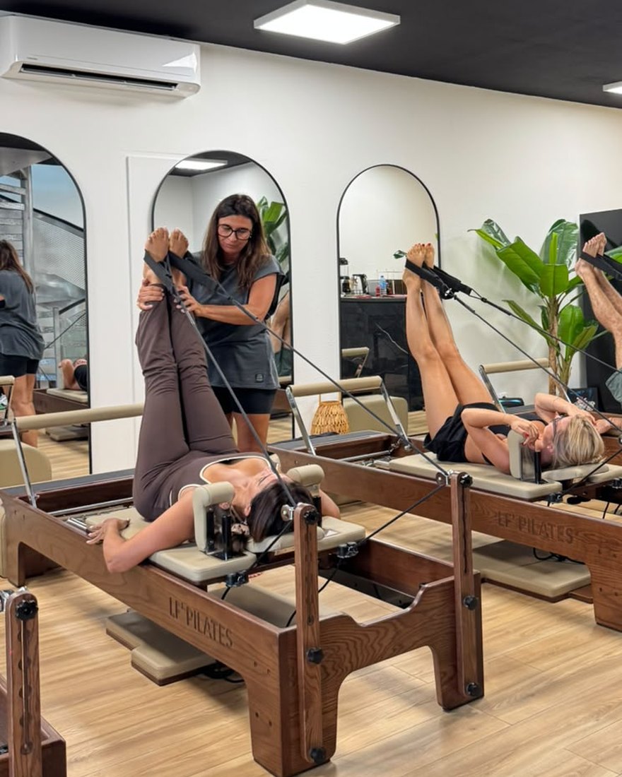 La coach Pilatéa corrige une cliente sur le Reformer
